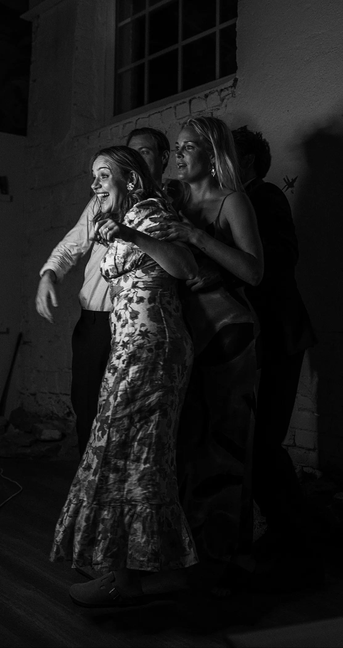 Black and white candid of guests embracing at the celebration, Sweden
